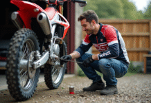 Homme nettoyant la chaîne d'un motocross 125cc en extérieur